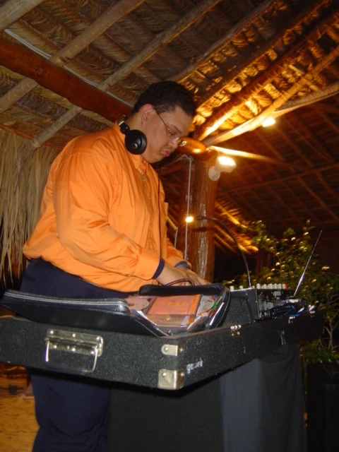 An archive photograph of Ruuben in an orange shirt working beside a CD wallet