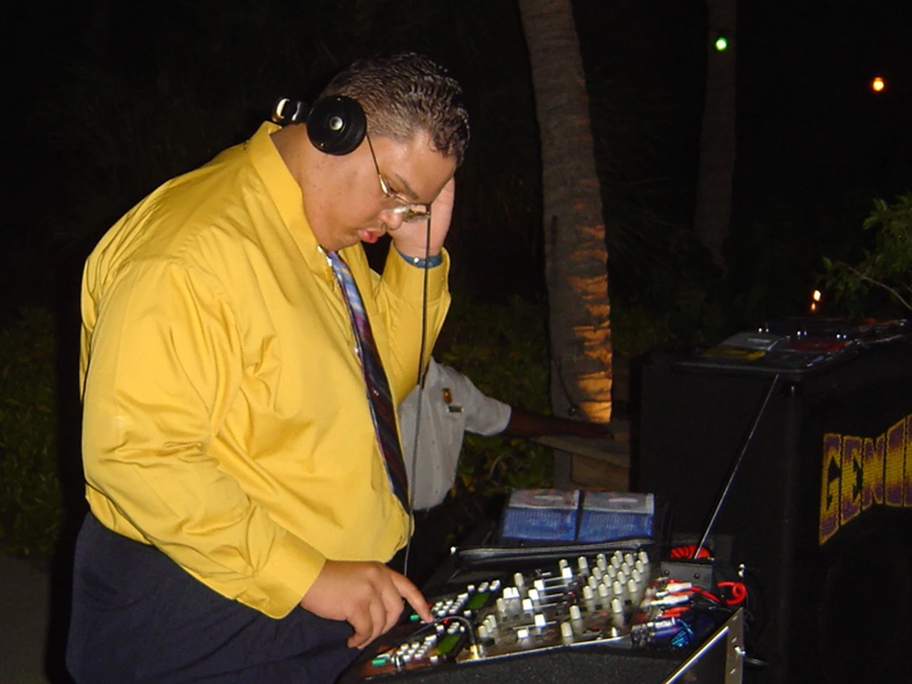 An archive photograph of Ruuben in a yellow shirt and tie, monitoring his mix
