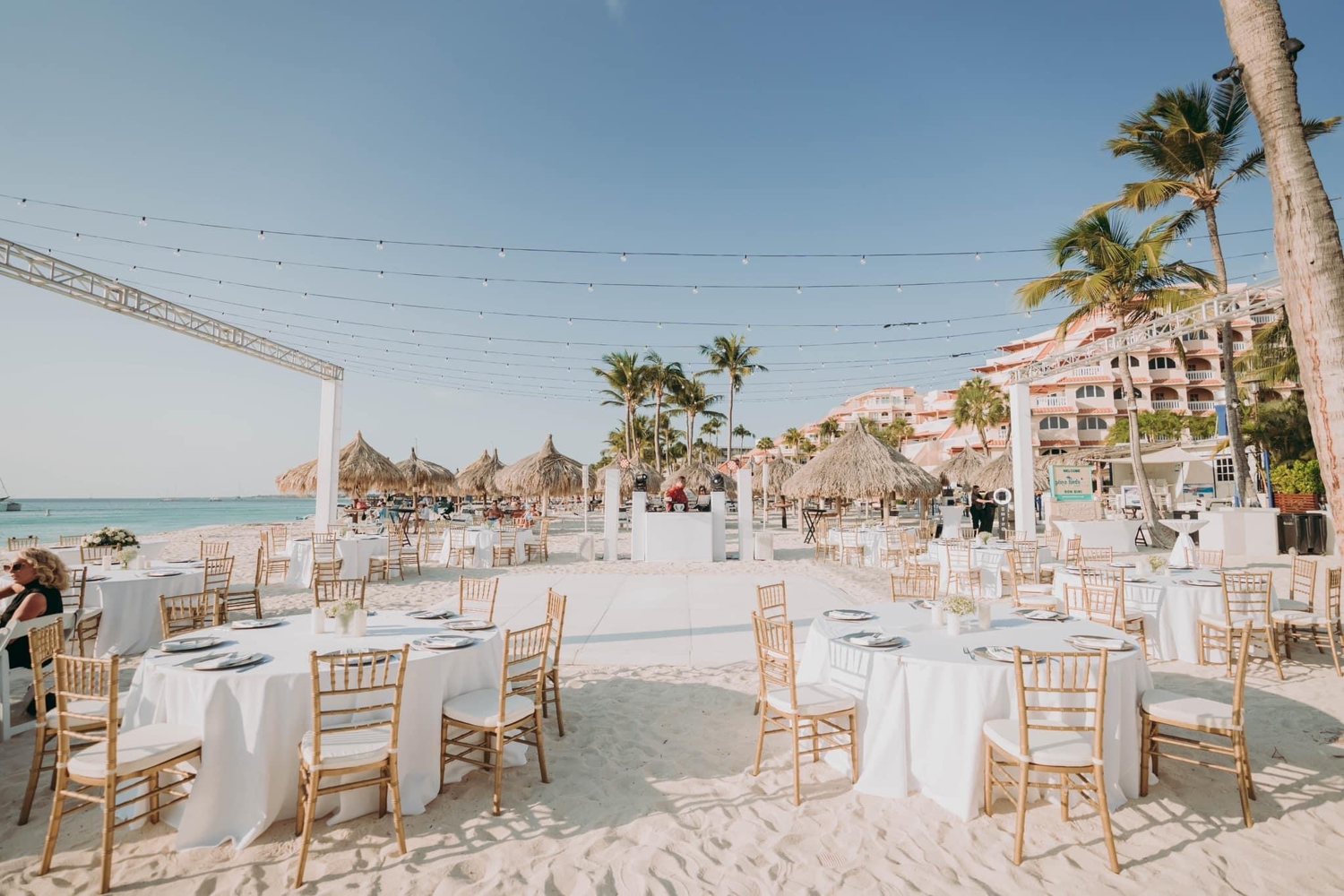 White reception tables and chairs beside the sea